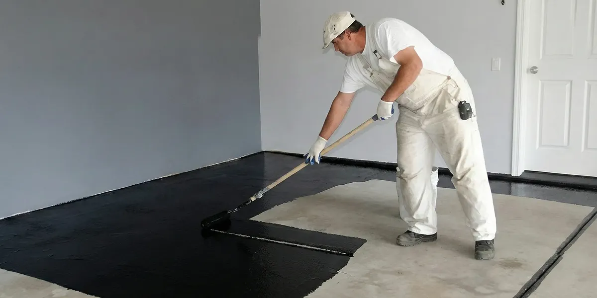 basement waterproofing professional applying waterproof coating to protect a basement floor in Spokane, WA